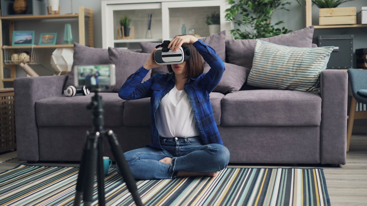 Woman sits on a striped carpet using a VR headset in a cozy living room.