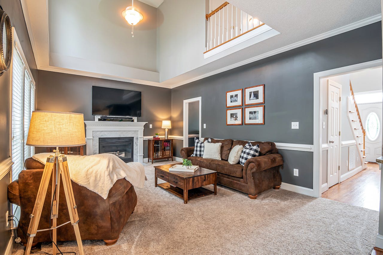 Spacious and elegant living room featuring a cozy fireplace, modern furniture, and warm lighting.