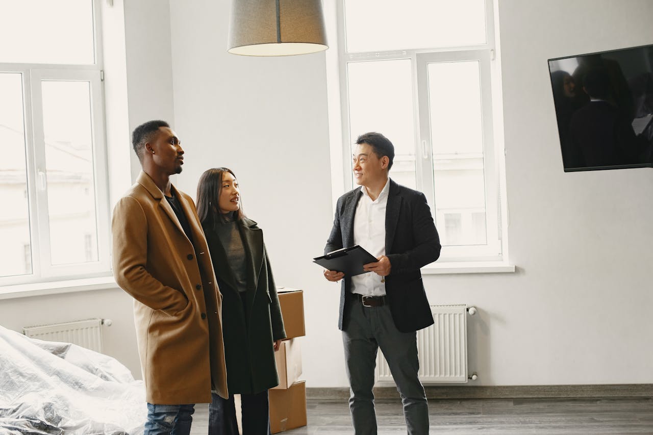 Real estate agent discussing property details with a couple in a modern room.